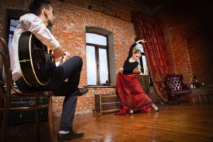Young Woman Dancing Flamenco And A Man Playing The Guitar